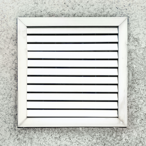 Aged vent with white shutters on the background of gray concrete under the leaves of the palm. Vent Cleaning